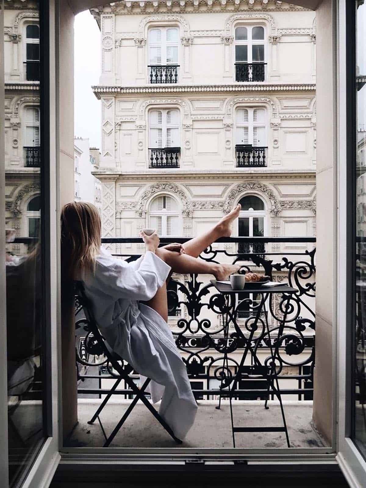 Woman looking out a window in Paris 