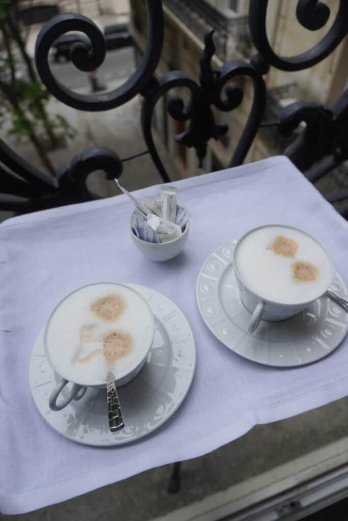 2 cafe cremes sitting on a tray in a white cup and saucer.