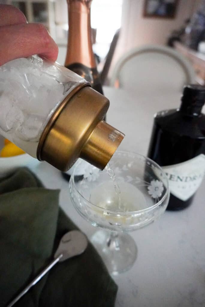 glass shaker pouring cocktail into a champagne couple
