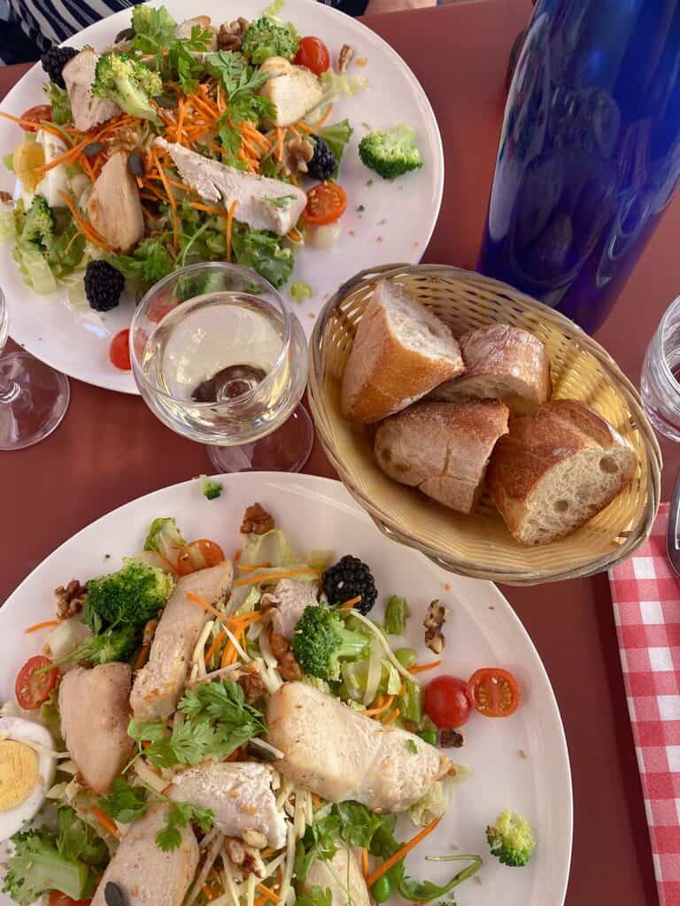 Garden salad and bread basket on table in Paris 