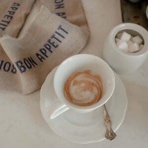 cafe creme sitting on a counter with a towel and sugar bowl