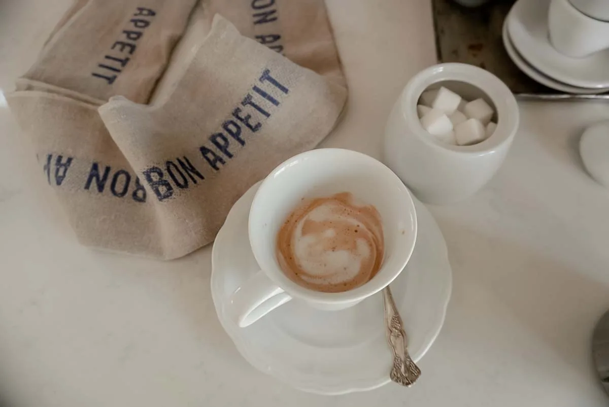 cafe creme sitting on a counter with a towel and sugar bowl