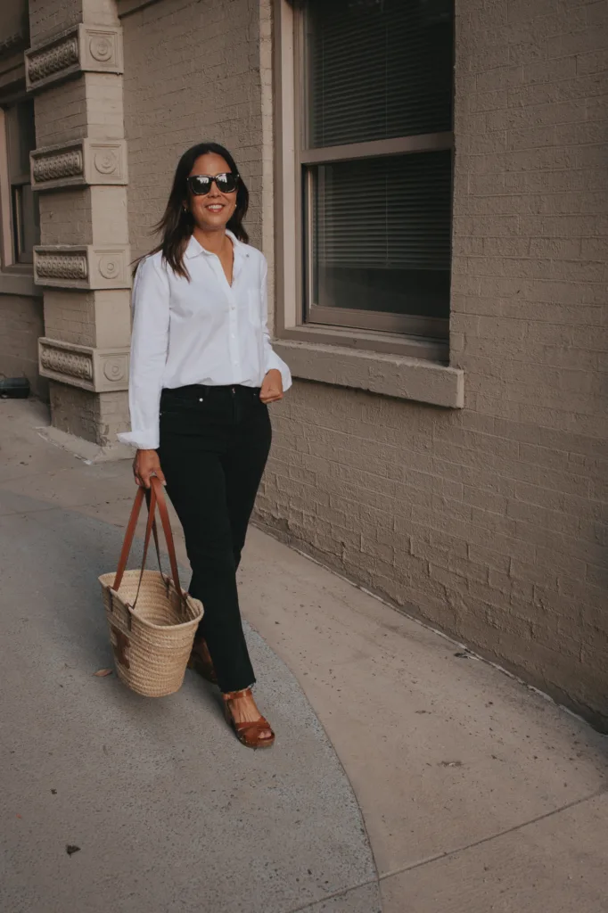Lady in white button down wearing black jeans, carrying market tote | A Guide To Sézane Sizing