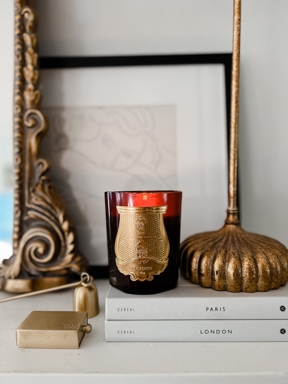 Red candle sitting on mantle with lamp