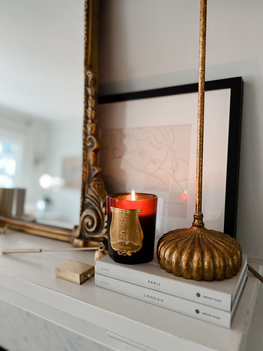 Red Candle for french fall sitting on a mantle
