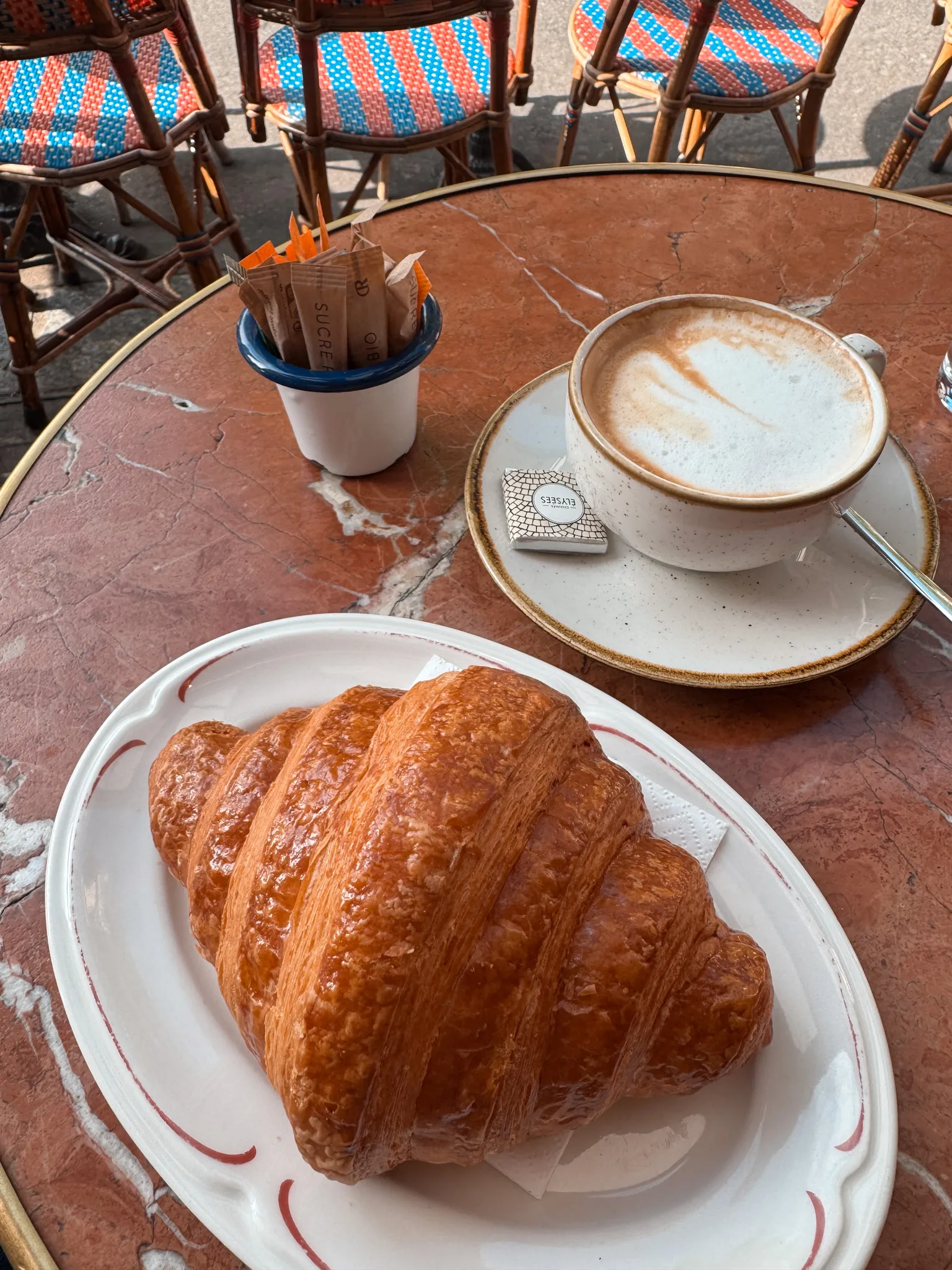 Coffee and croissant sitting on a table in Paris.