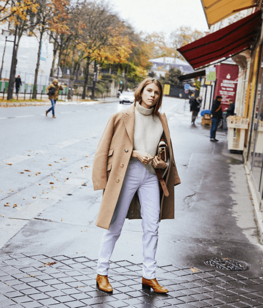 Lady in Paris on the street wearing a camel coat and white jeans