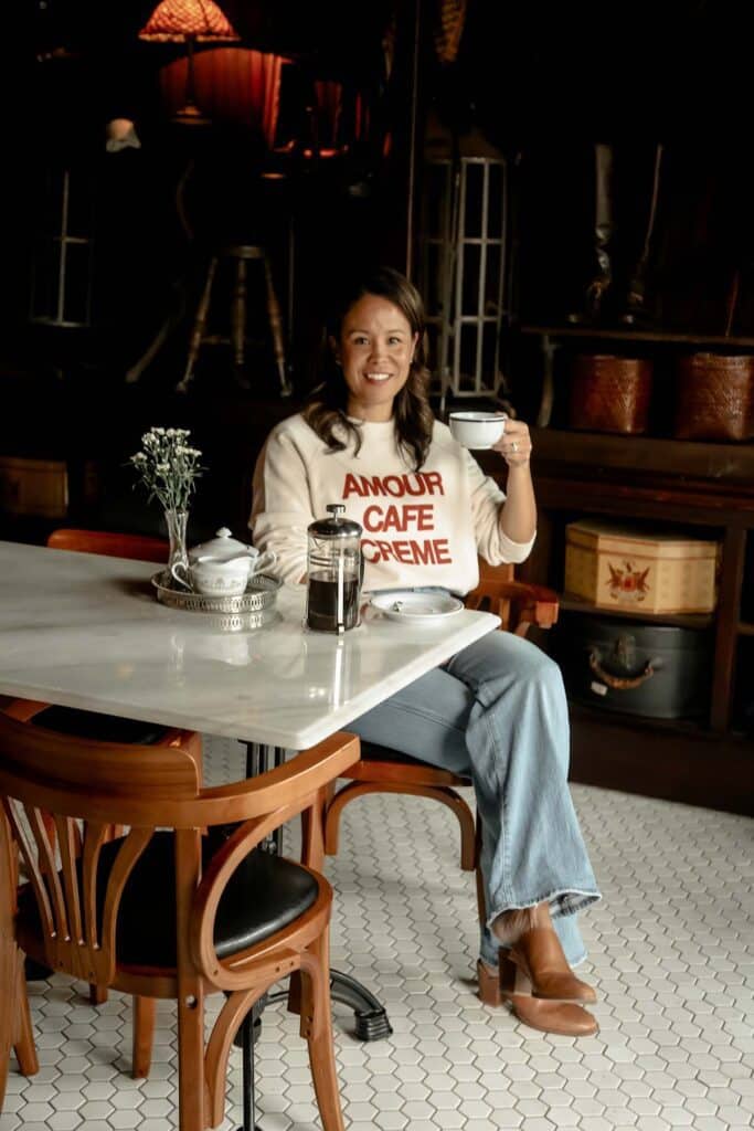 sitting in a restaurant holding a coffee cup