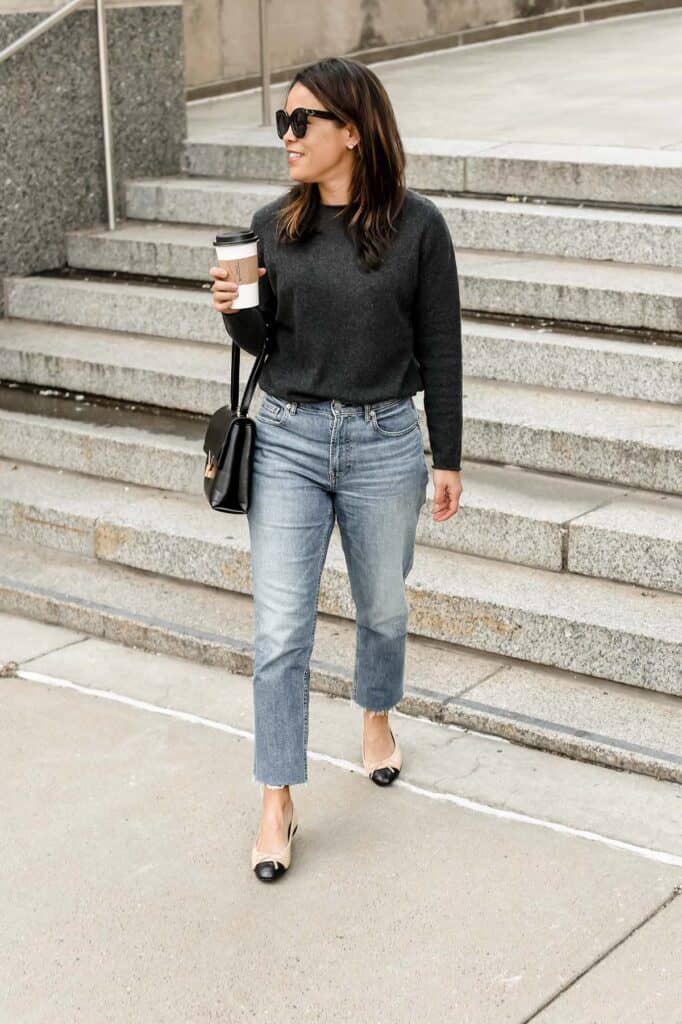 wearing a dark grey cashmere sweater holding cup of coffee