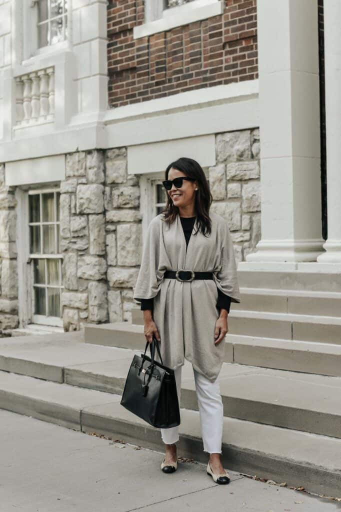 standing with wrap and belt in front of building