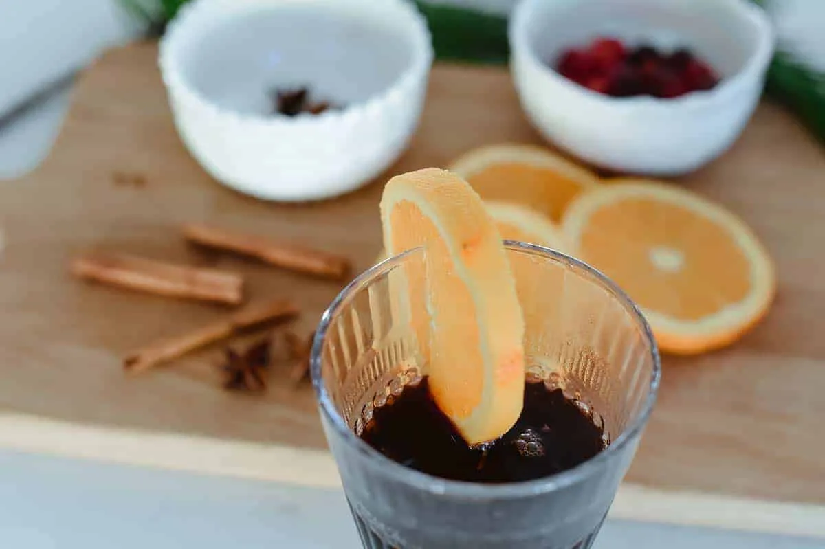 orange slice atop a glass on vin chaud sitting on counter