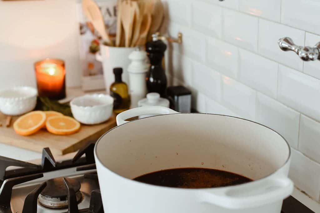 dutch oven dutch oven sitting on stovetop with candle lit in the background.
