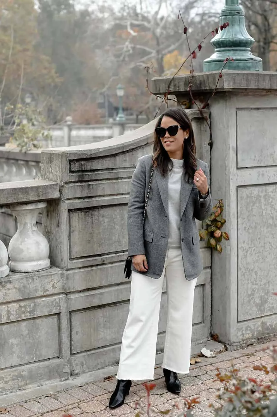 standing wear grey blazer with white jeans