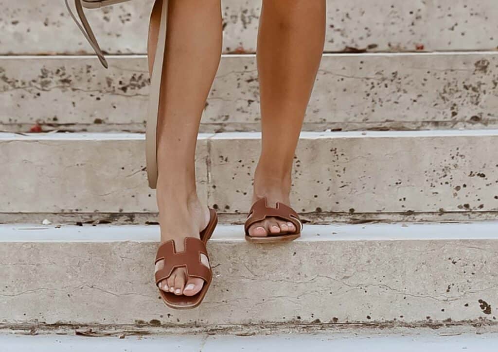 wearing hermes sandals walking down the stairs