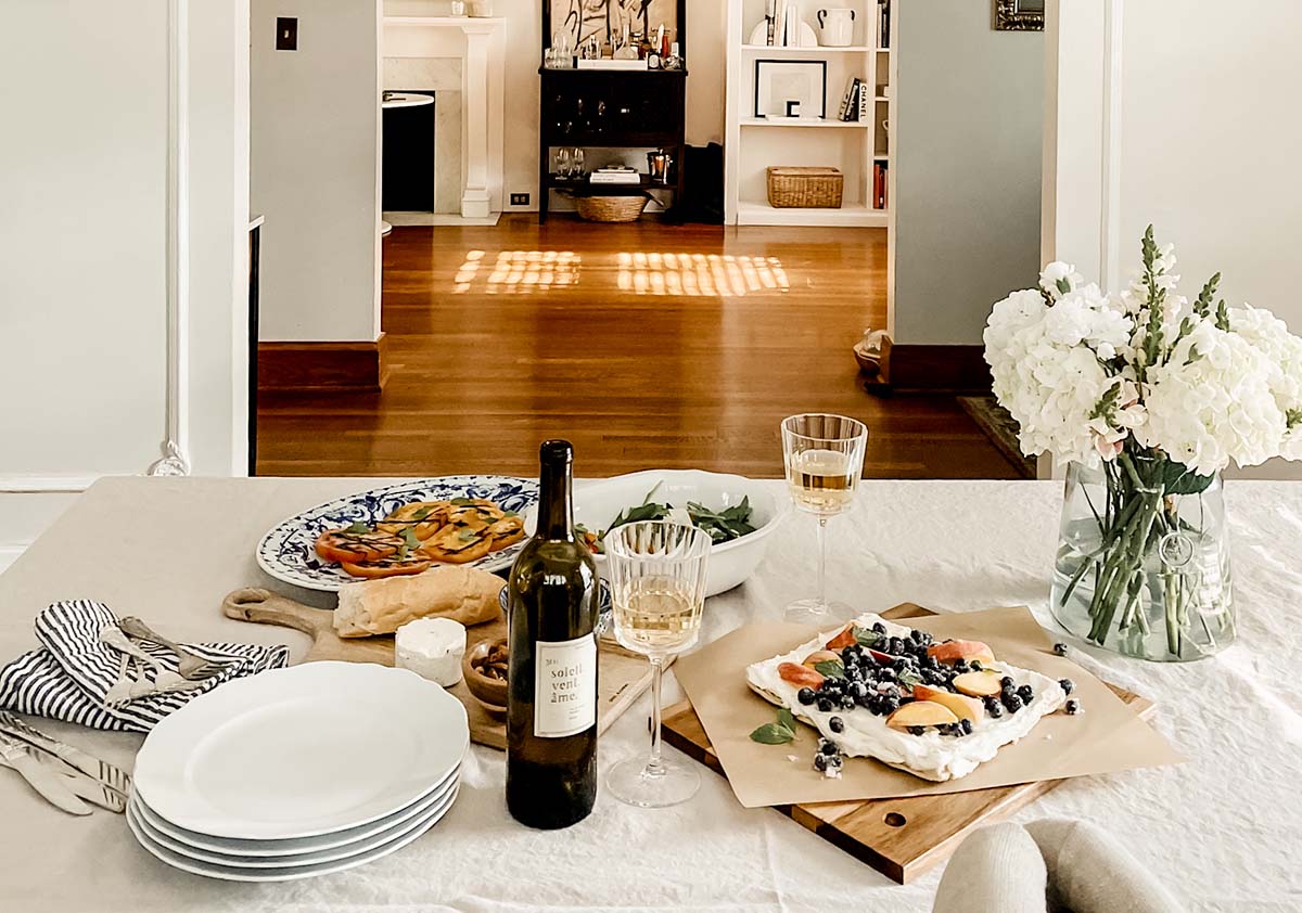 Wine bottle and fruit tart sitting on a table