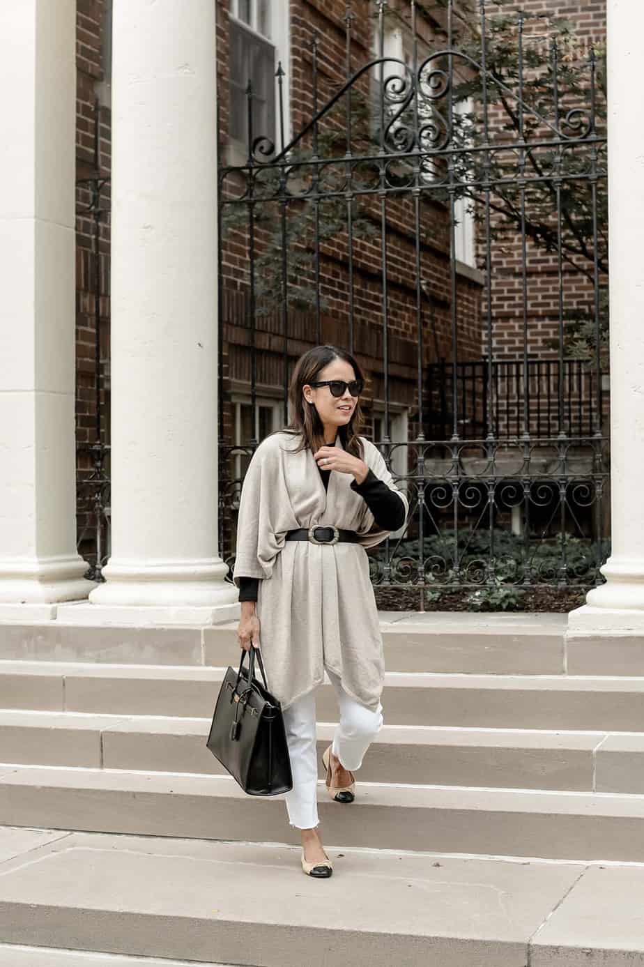 wearing mer sea wrap with white jeans and holding black purse