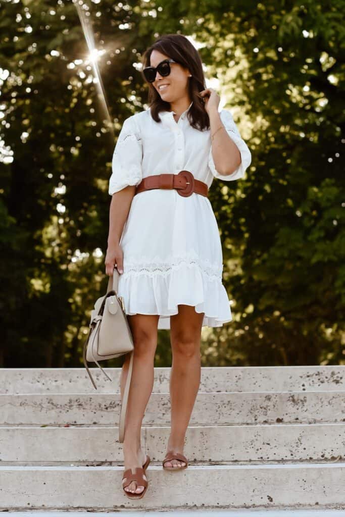 standing on staircase outside in paris with white dress