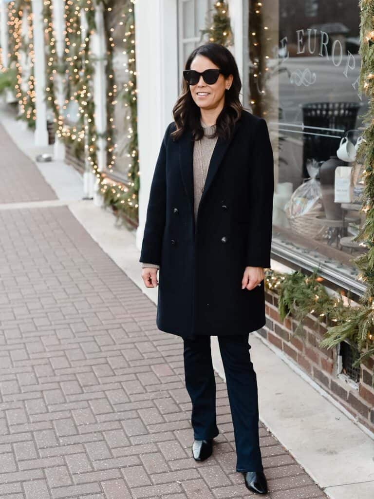 me wearing navy coat and jeans outside of a coffee shop