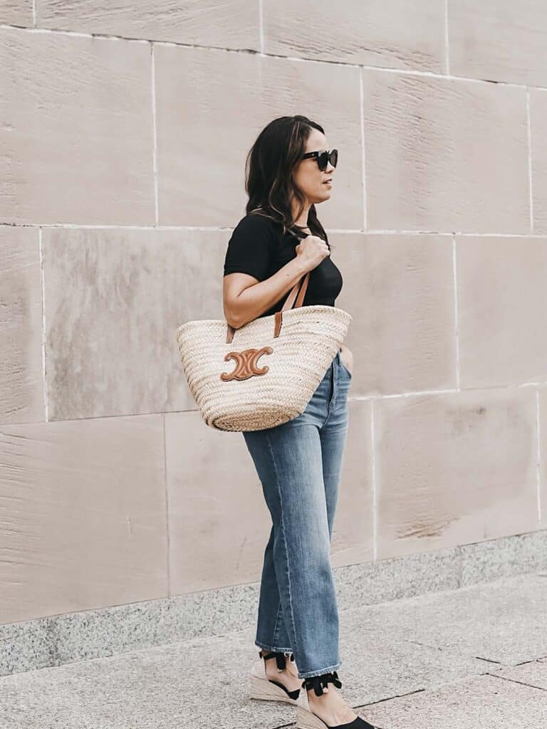 me standing against wall holding celine straw tote