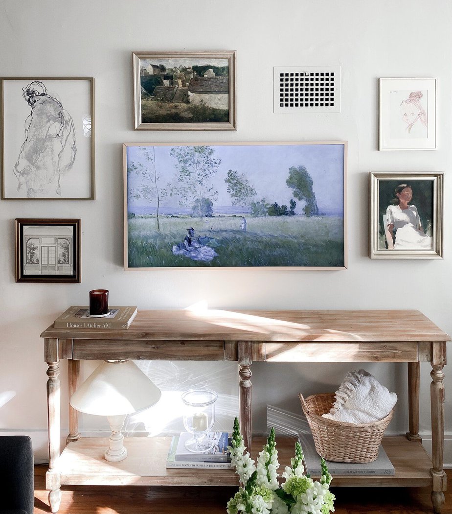 french art on a wall with console table and sun shining through 