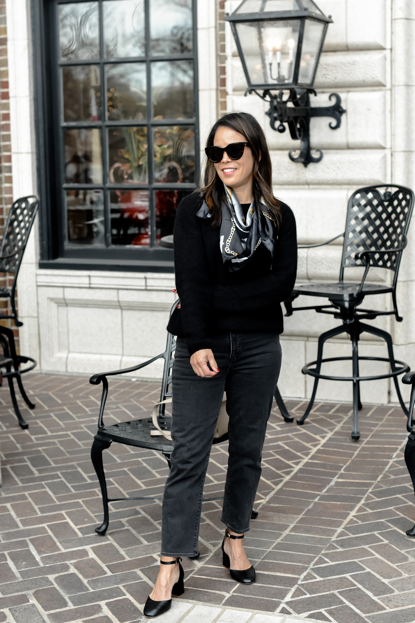 wearing black jeans, sweater, and scarf 