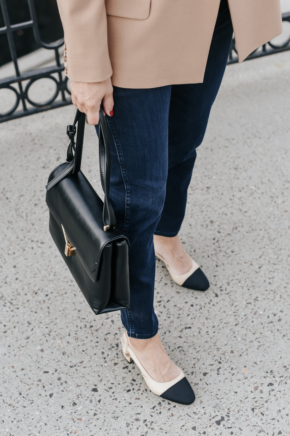 jeans, pumps, and holding black purse wearing camel blazer