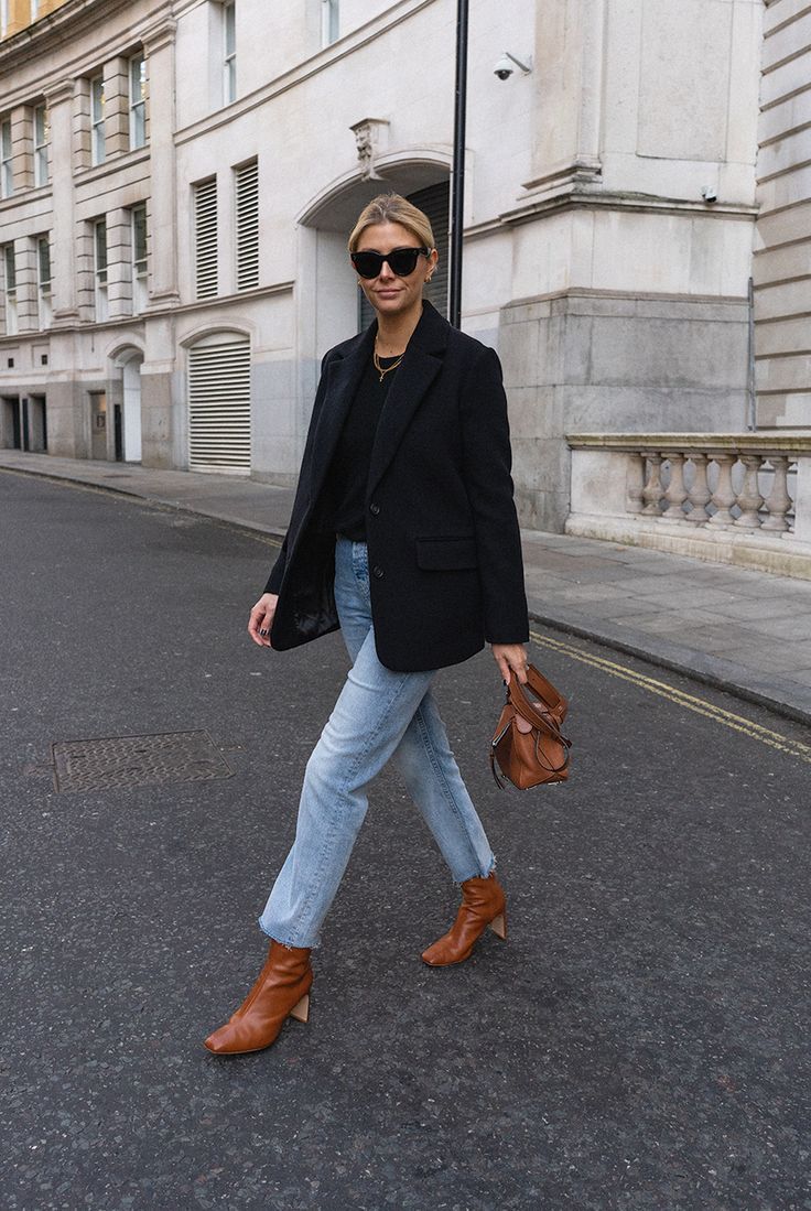 emma hill wearing black blazer and jeans and brown boots