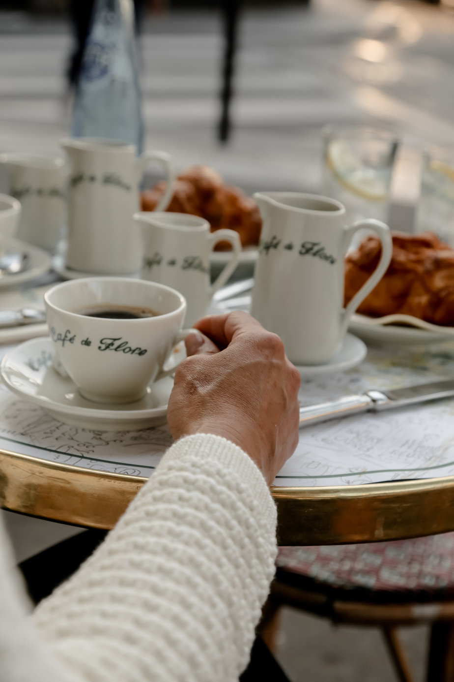 holding a coffee cup which says cafe de flore