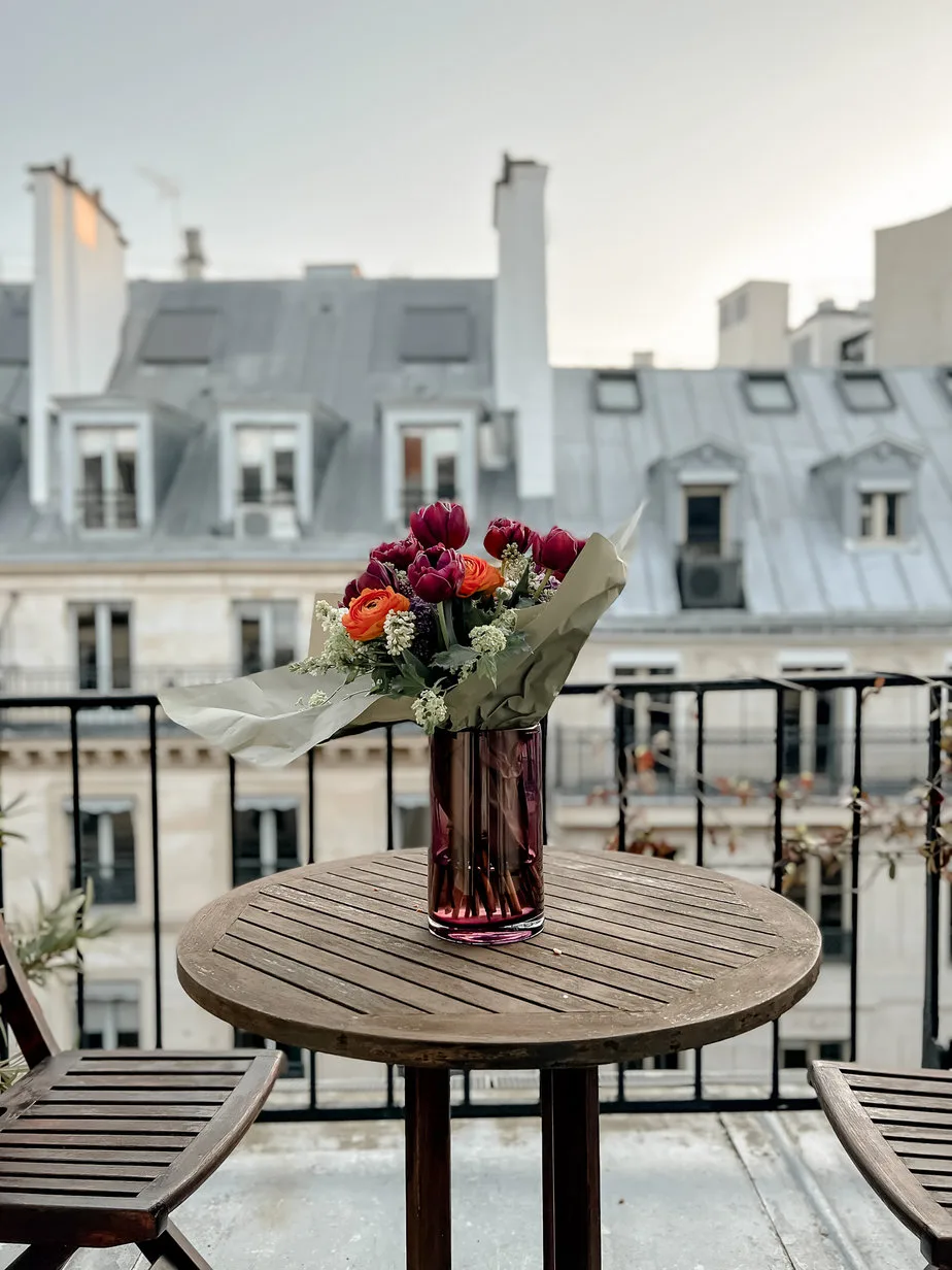 flowers in a vase on a patio in paris