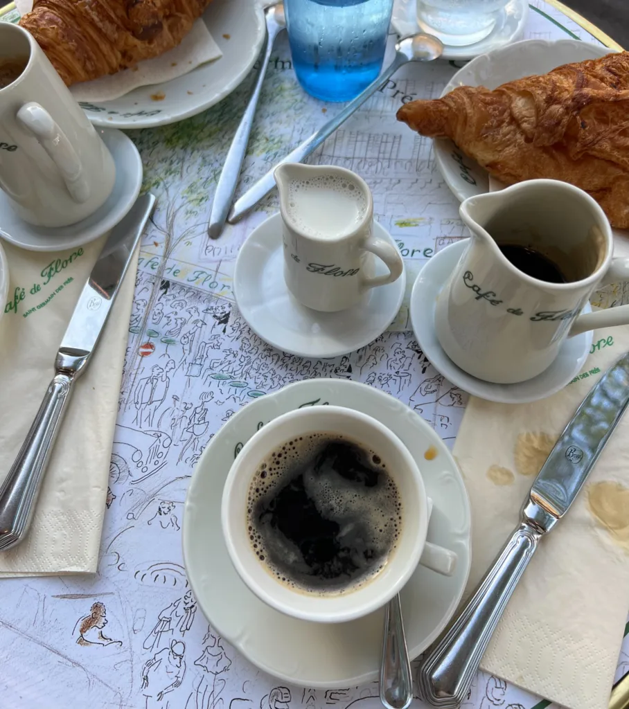 Black drip coffee sitting on a table at cafe de flore.