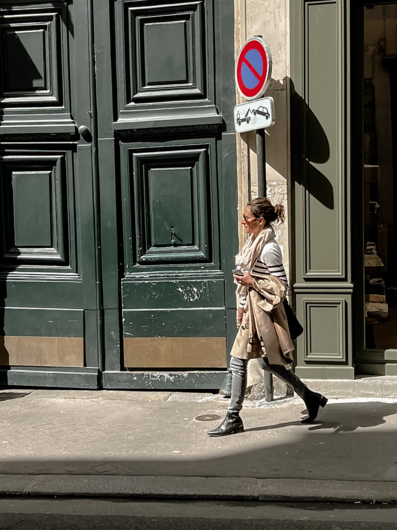 lady in trench coat with striped top, jeans, and boots in Paris