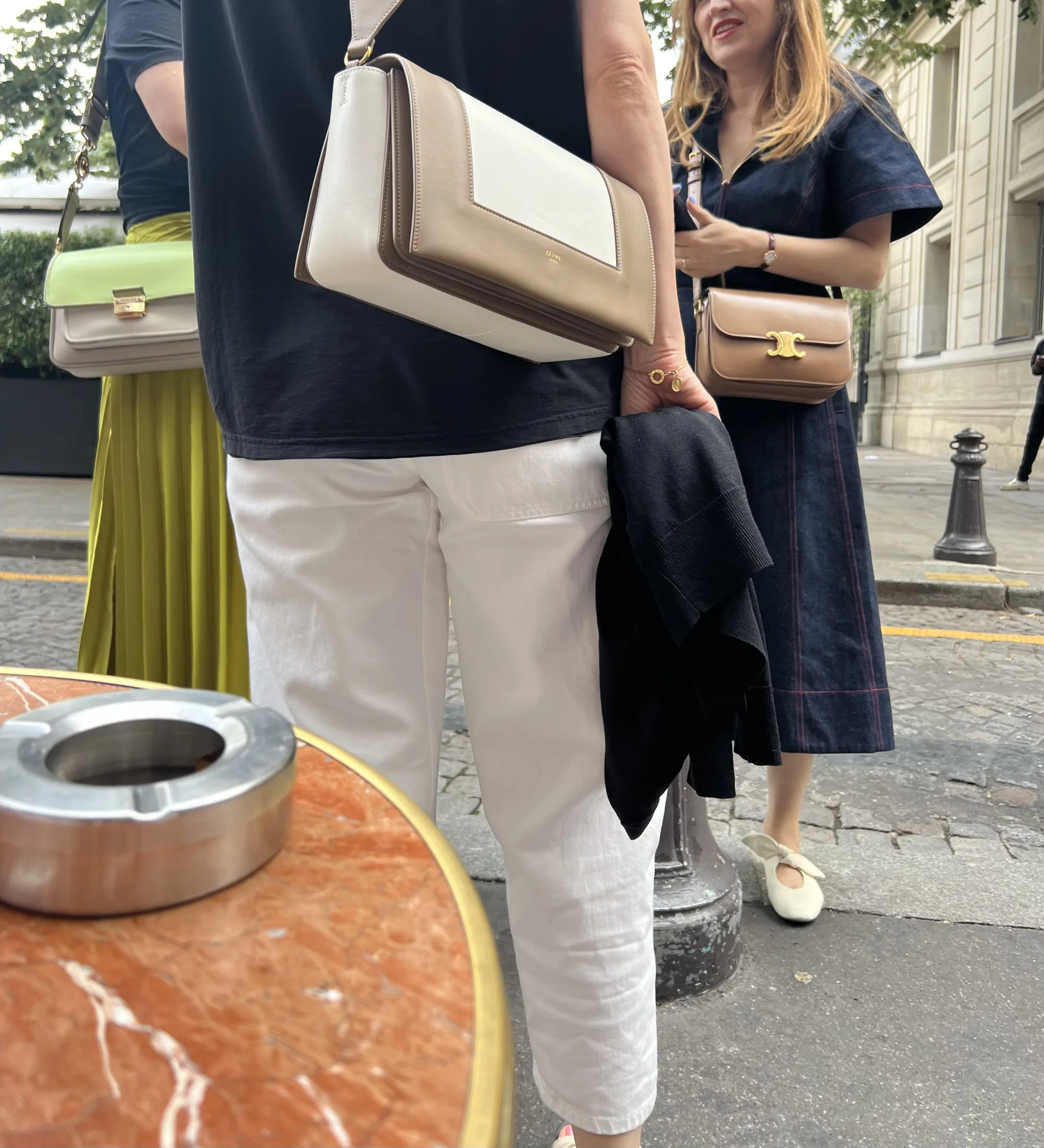 Women with Celine bags standing talking in Paris.