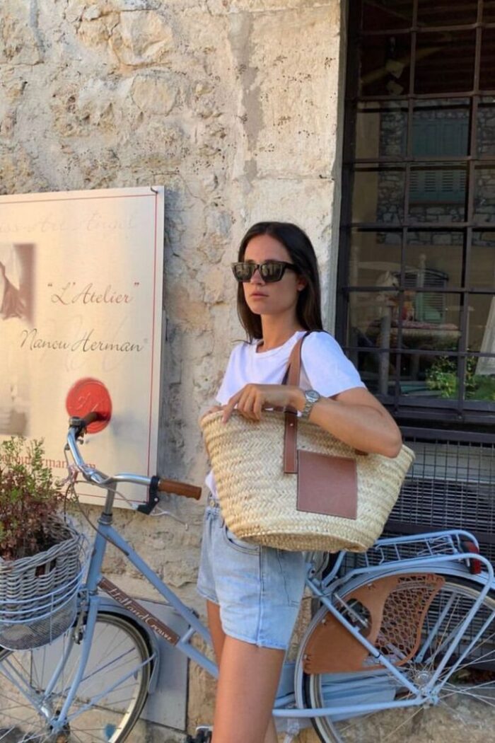parisian girl in denim shorts parisian girl in denim shorts with white tee and straw tote