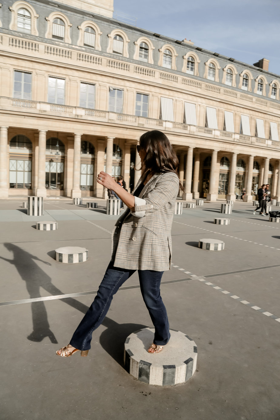 wearing blazer and jeans going through palais royal in paris 