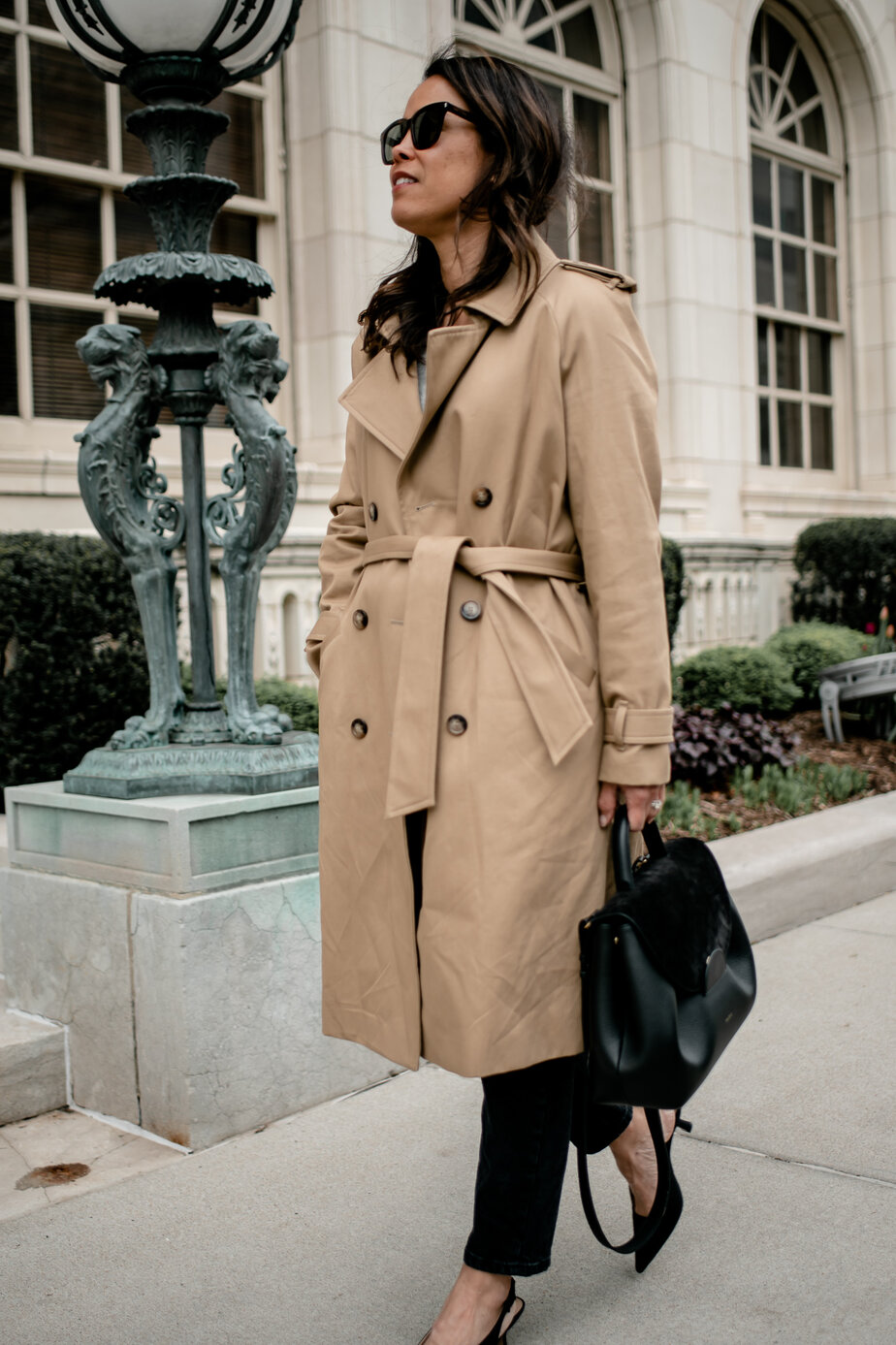 wearing a trench jacket walking down the street 