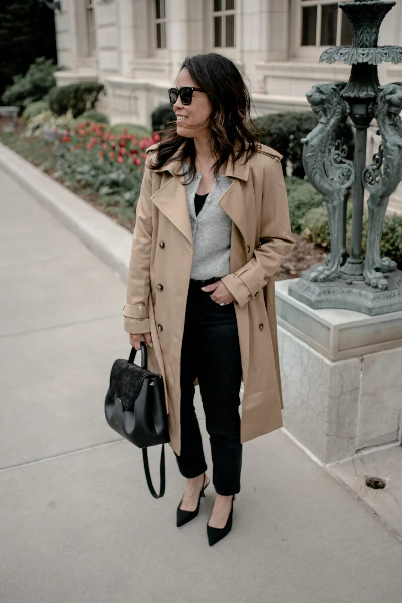 wearing a trench coat with jeans and black pumps.