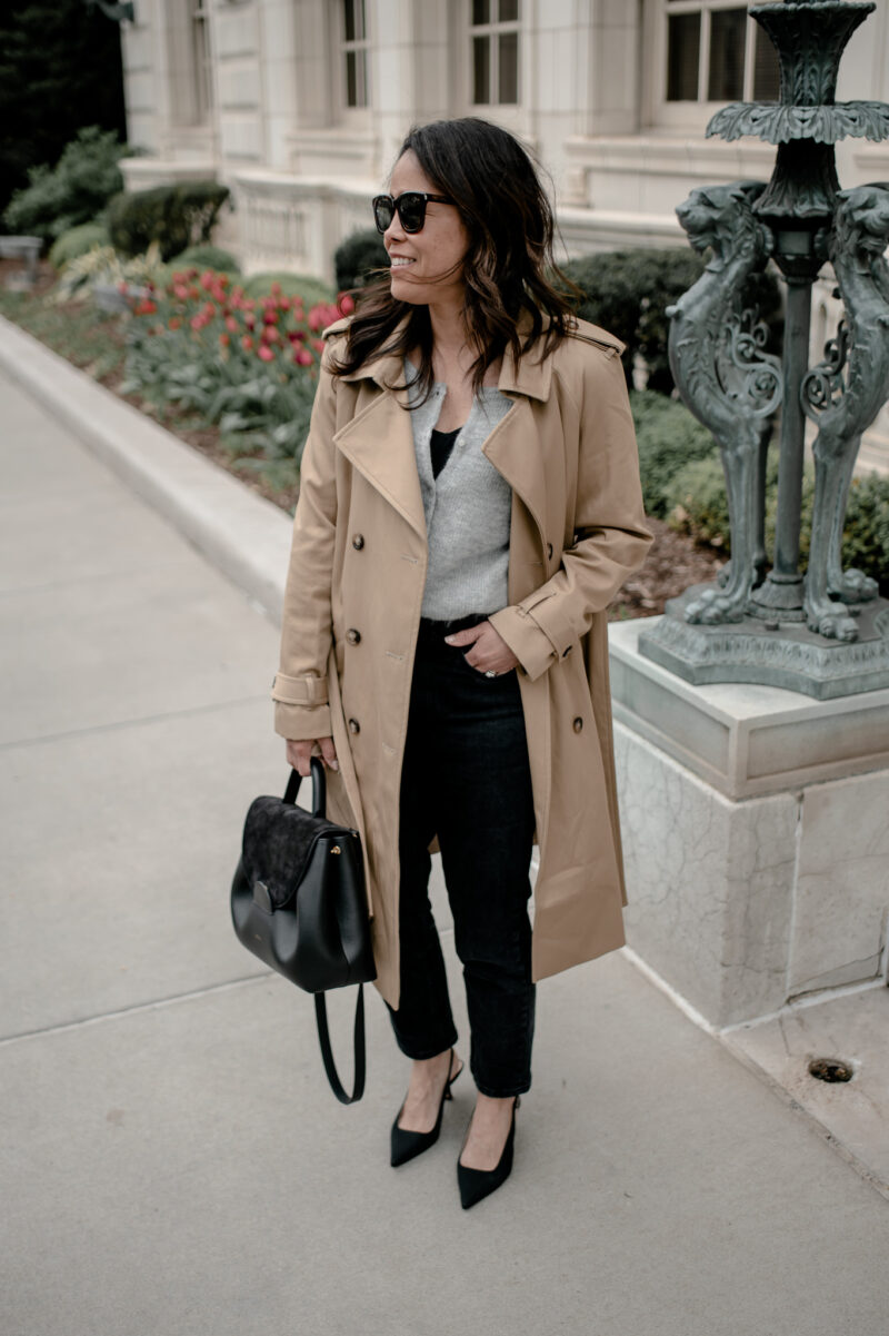 wearing a trench coat with jeans and black pumps.