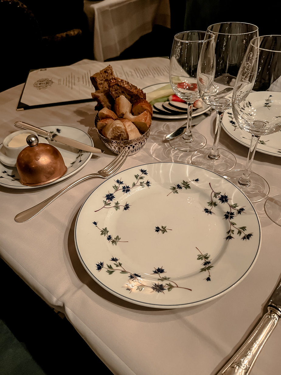 Copper butter dish and blue and white plate on a table part of essential guide to saint germain des pres.