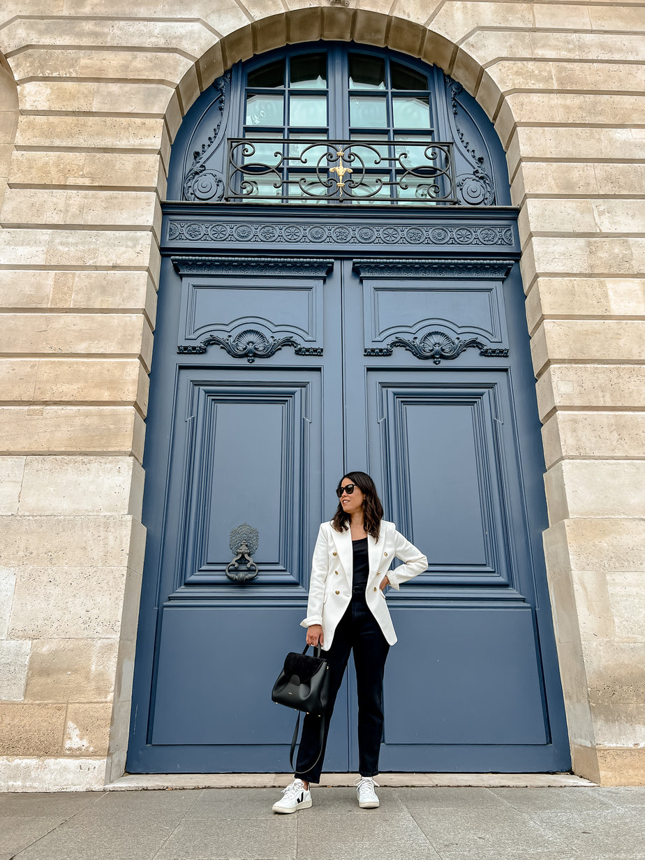 standing in front of blue door in paris