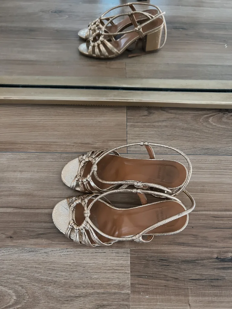 gold sandals sitting on the floor.