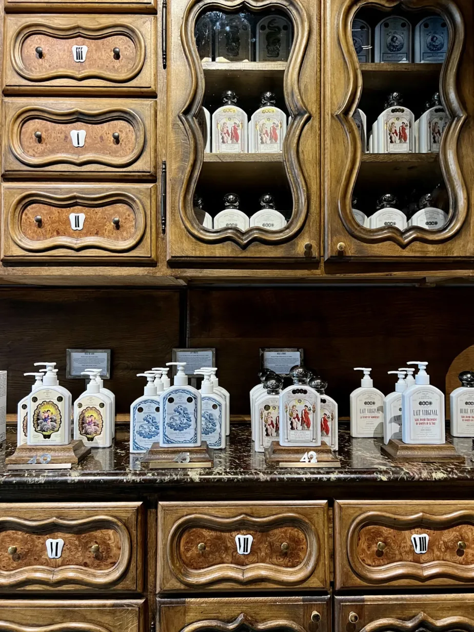 Different bottles of lotion sitting on a wood cabinet. Store for shopping as part of an essential guide to saint germain.