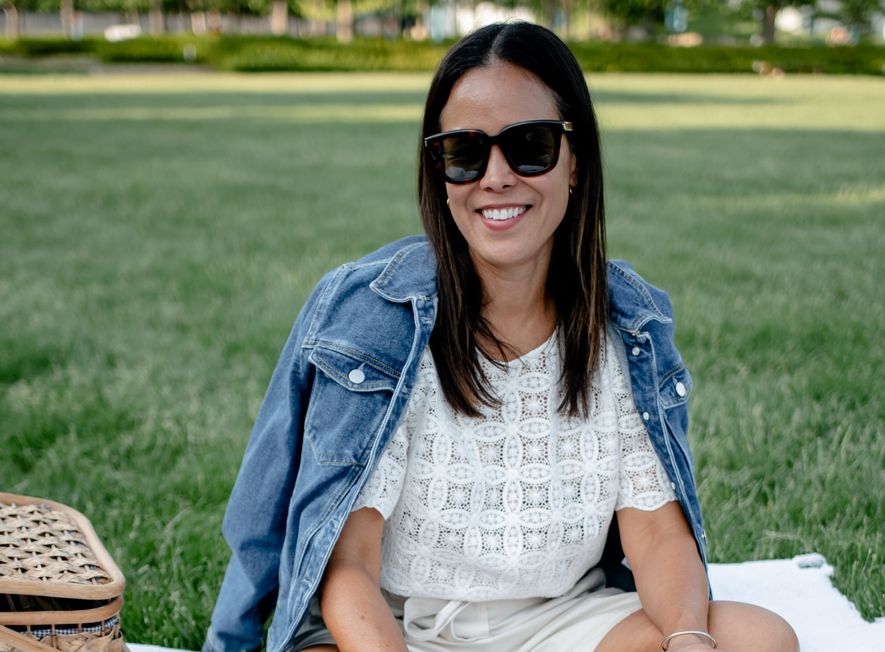 Wearing Sèzane Denim Jacket With White Top Sitting On The Lawn