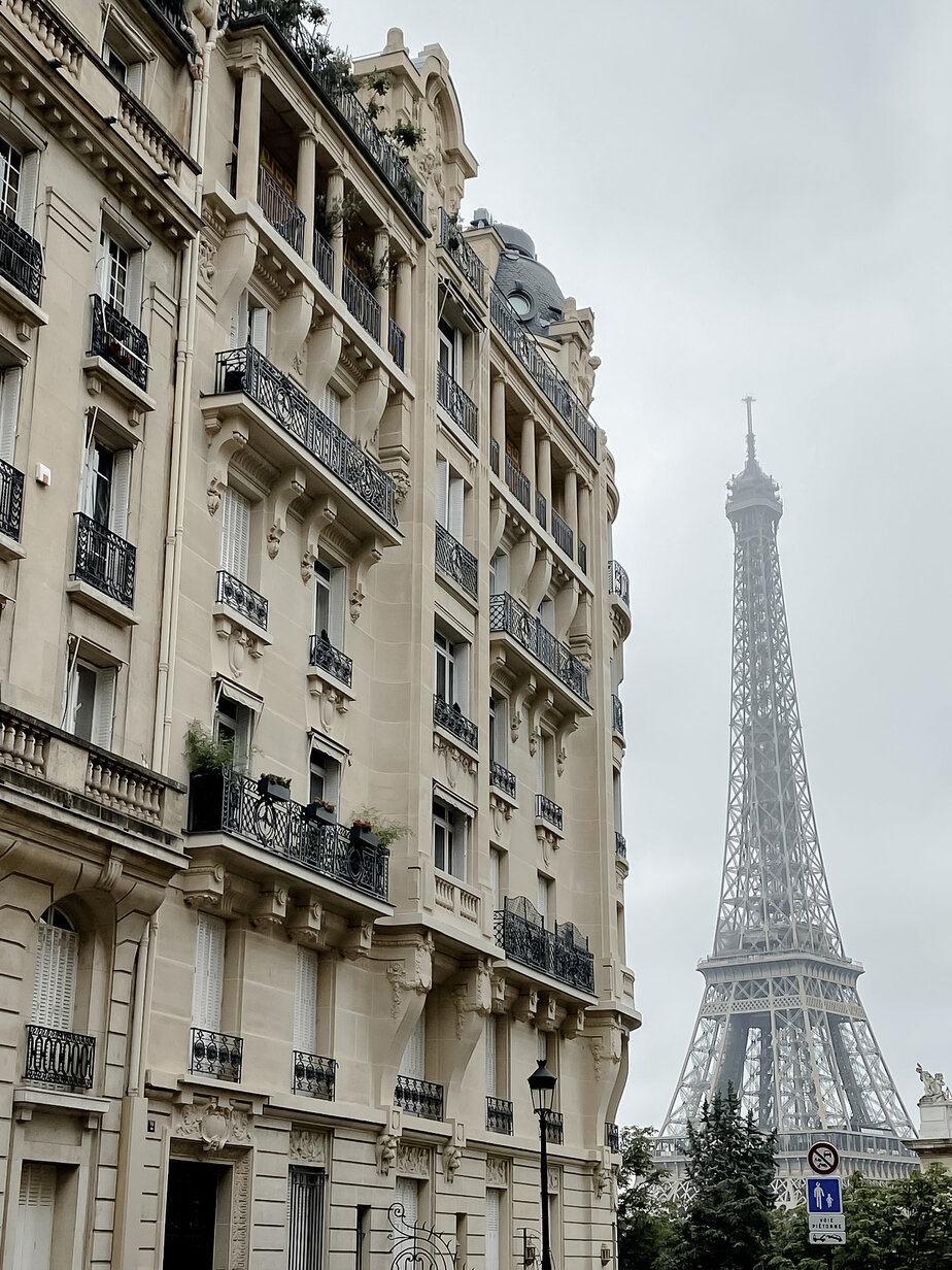 Eiffel Tower in the background on a famous avenue in Paris on a cloudy grey day