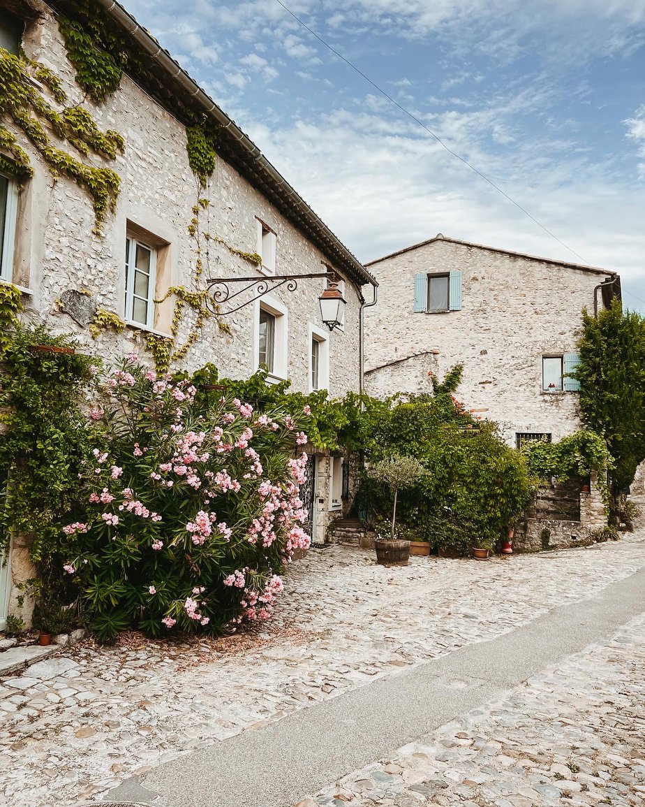 homes with blue shutters and pink flowers in provence