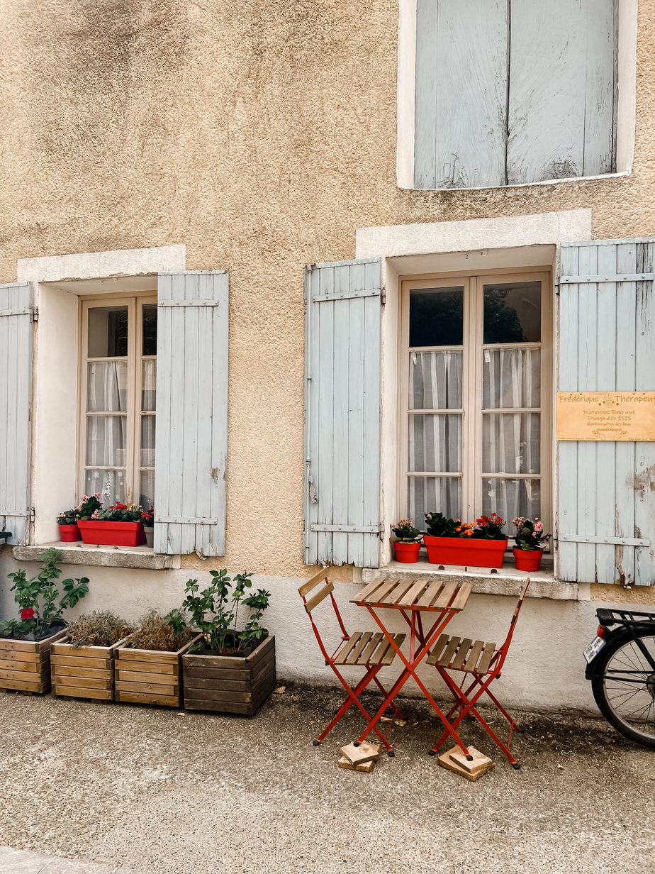 house in provence blue shutters with bistro set sitting in front of house in provence