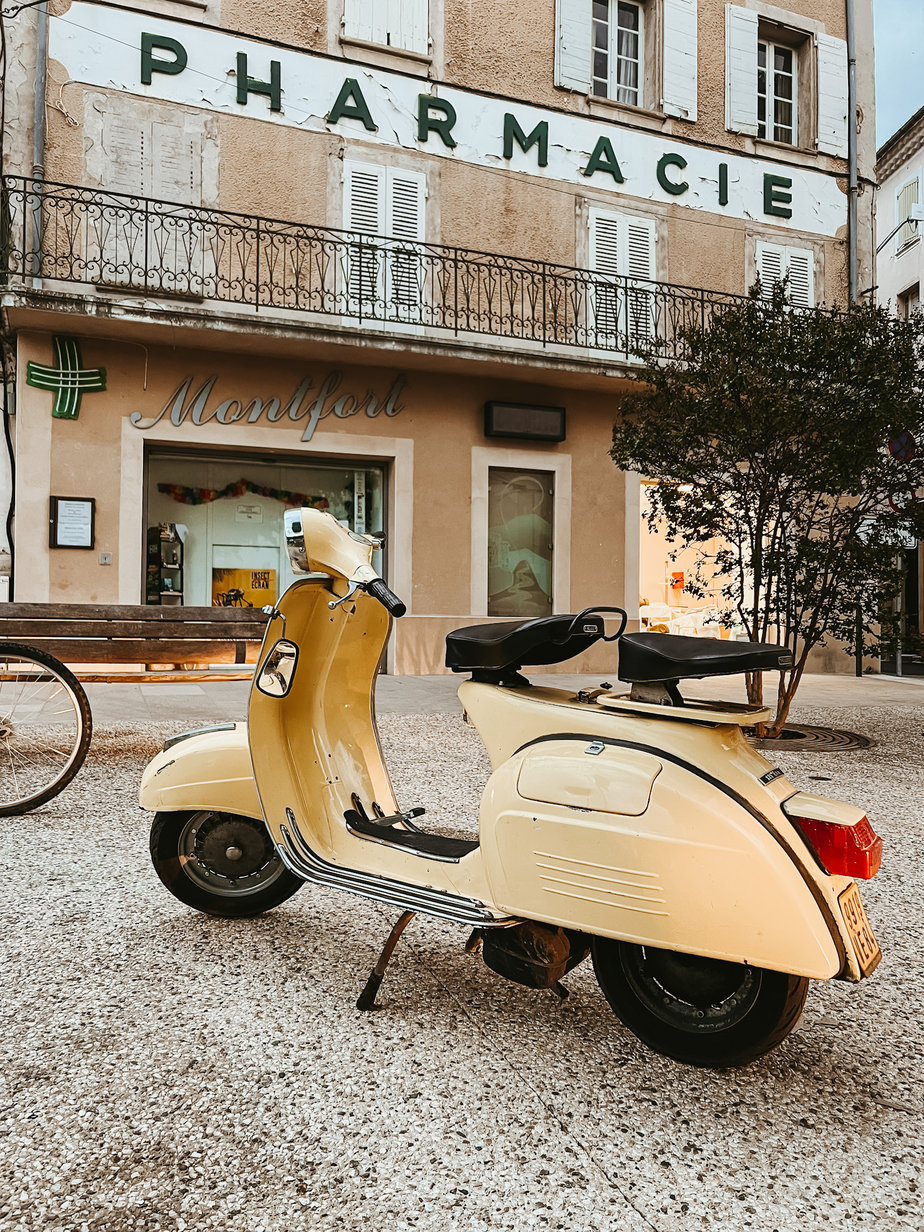 yellow vespa in front of pharmacie in provence