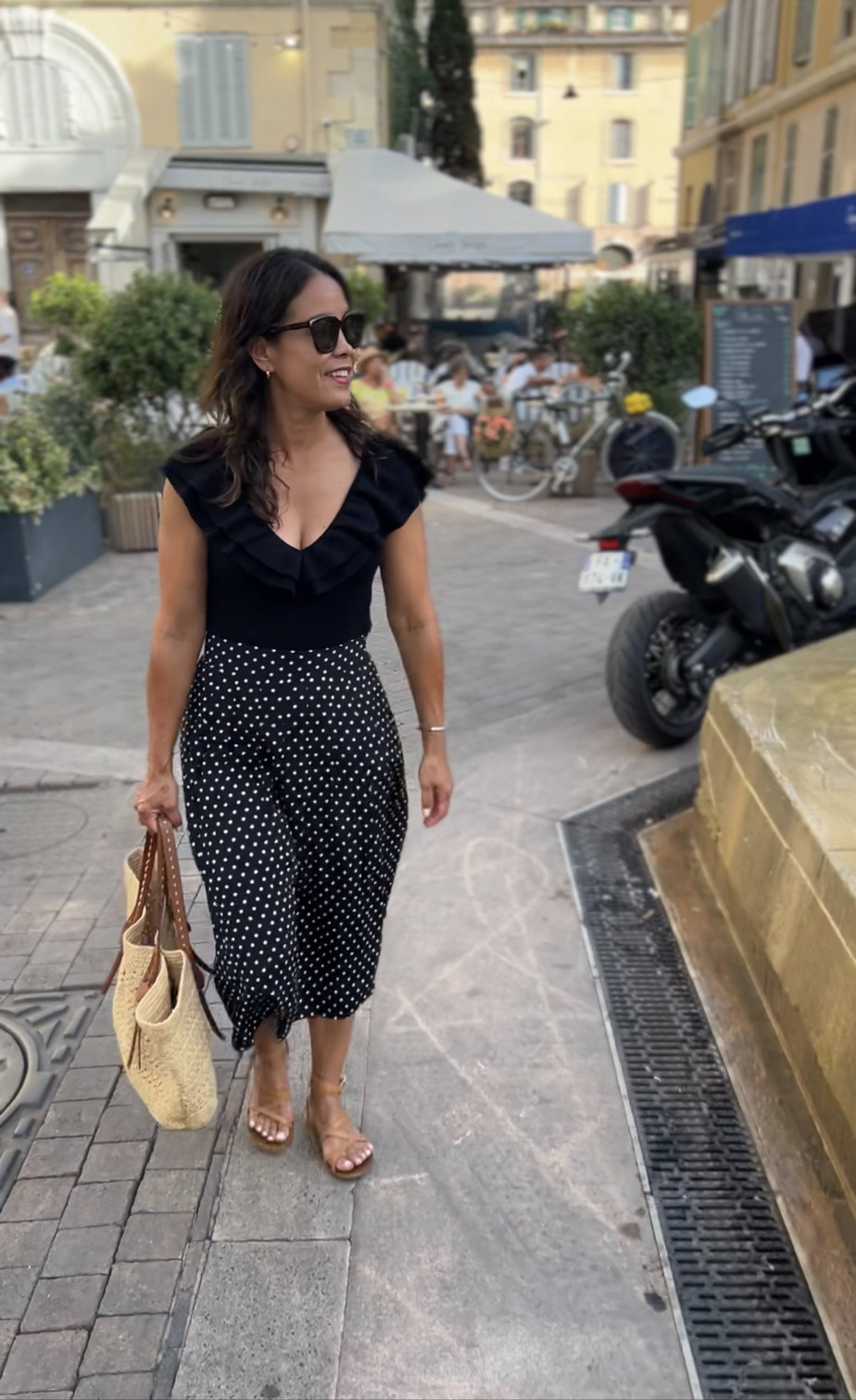 wearing black polka dot skirt with body suit and market tote in Marseille 