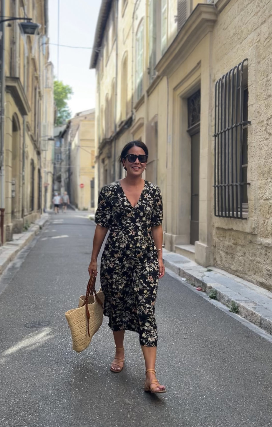 Wearing floral black dress with sandals and carrying market tote