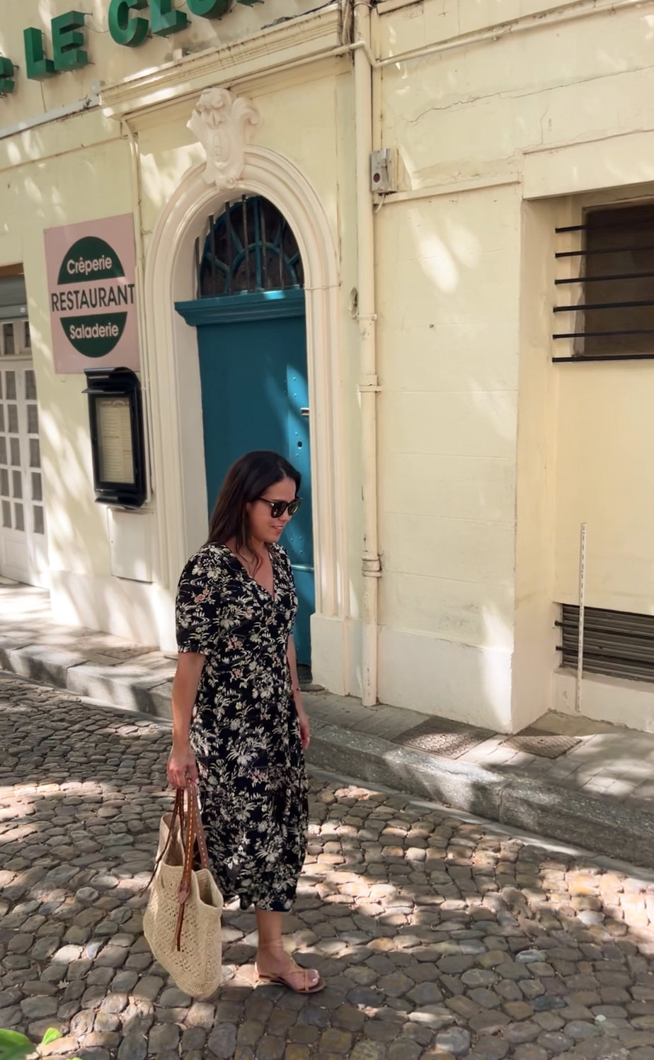 Wearing floral black dress with sandals and carrying market tote