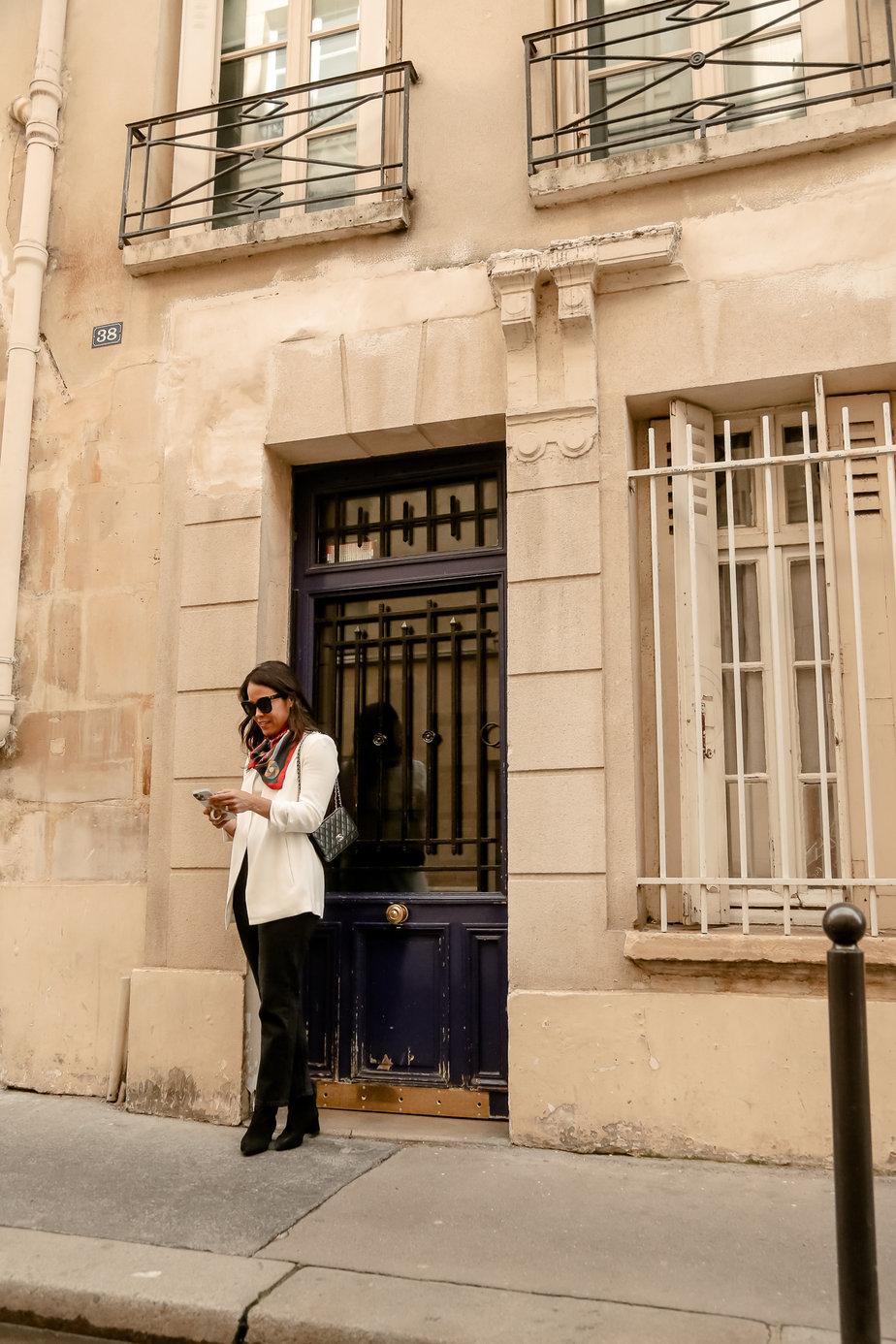 Wearing white blazer with black jeans and boots in Paris